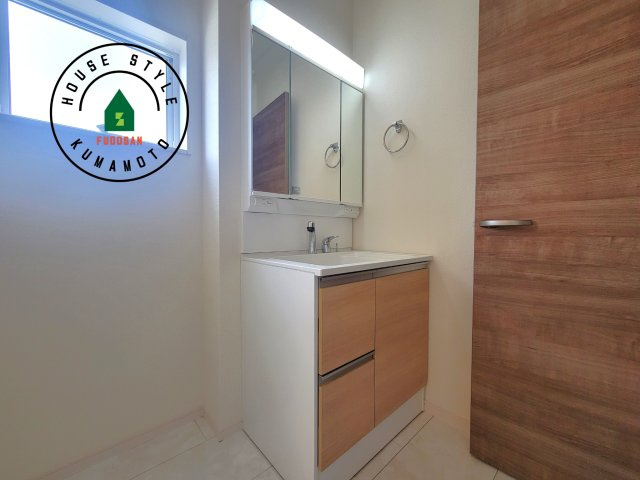 合志市竹迫第1-3棟（2号棟）の独立洗面台|毎日使うものだから清潔な空間を保ちたい水回り。洗面にはそんな願いを解消させてくれる収納アイデアが満載です。三面鏡の裏側にはキャビネットが現れ小物から背の高い物まで収納できます。