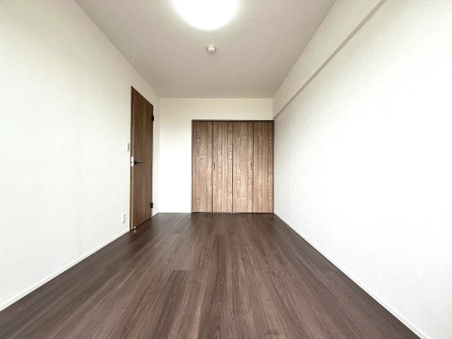 忠道マンションA棟の洋室|広々とした空間が広がる洋室。十分な広さがあるので寝室としてはもちろん、書斎や趣味の部屋としても活用できます。収納力のあるクローゼットが、多様なライフスタイルをサポートします。