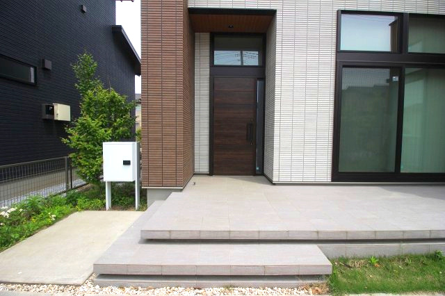 小山市神鳥谷の玄関|ステップ付きで安全性に配慮された玄関アプローチ。スタイリッシュで重厚感のある玄関ドアが印象的です。