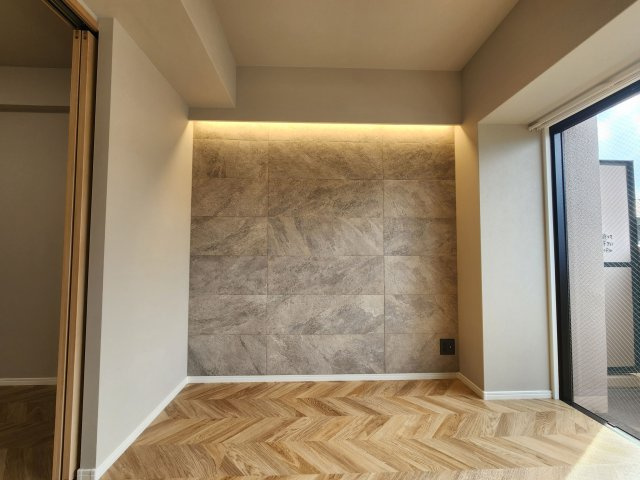 【居間・リビング】 | コアマンション博多南 | おしゃれなヘリンボーン柄のフローリングにデザインクロスの組み合わせで大人っぽい雰囲気を醸しています