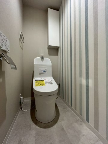 労住まきのハイツ一号棟のトイレ|ストライプの壁紙でお洒落なトイレです。