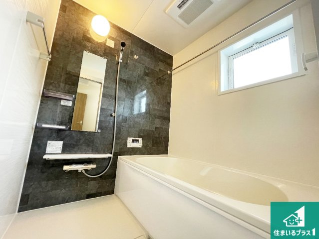 亀岡市余部町清水　新築一戸建ての浴室|足をゆったり伸ばして寛げる浴槽です。窓が設けられていますので差し込む光が明るく穏やかな雰囲気にしてくれます♪浴室乾燥機も設置しているので、雨の日の洗濯物も安心です♪