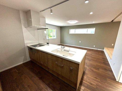 千年1丁目　モデルハウス分譲のキッチン|リビングを見渡せる対面式システムキッチン。温かみのある色合いが印象的です。