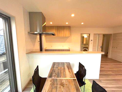 大明丘1丁目　モデルハウス分譲のキッチン|キッチンの前にはダイニングテーブルを置けます。家具の配置がイメージしやすいですね。