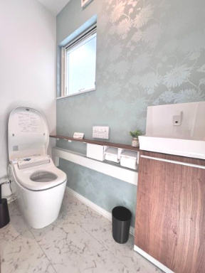 富久山久保田　モデルハウス　ネクスト　戸建てのトイレ|壁紙がアクセント、収納棚も充実した機能的でおしゃれなトイレ空間。