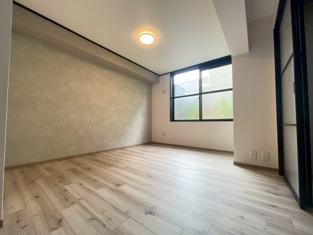 【価格改定】ルシエル向日町駅前の洋室|木目の優しいフローリングと黒フレームのスライドドアで、洗練された空間に。