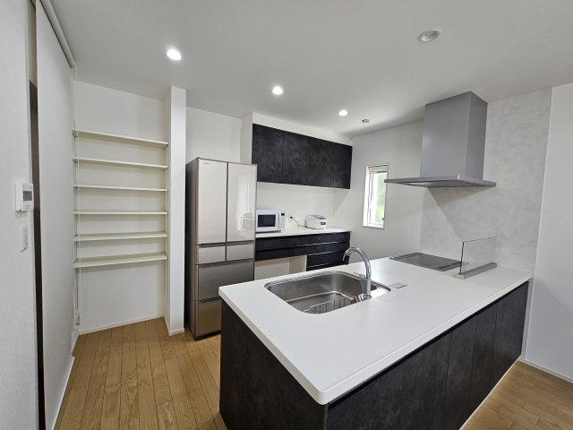 野田市五木新町　中古戸建　令和5年築のキッチン|広々とした空間で快適に料理をすることができます。
シックなペニンシュラキッチンの造りとなっており、落ち着いた雰囲気が魅力です。