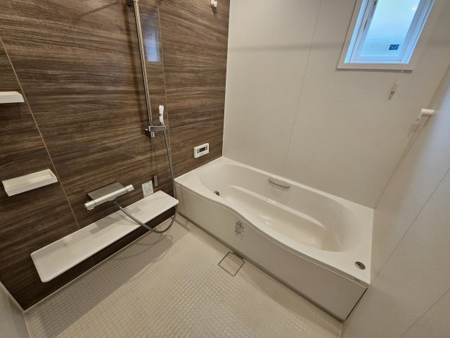野田市五木新町　中古戸建　令和5年築の浴室|坪設計の広い浴室です。浴槽もワイド仕様のため、家族みんなでゆったりお湯につかることができます♪　また浴室内にホスクリーンが設置されており、室内で洗濯物を干すことも可能です。
