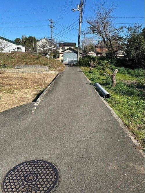 東田２丁目　売土地の前面道路含む現地写真|南側に農道があり陽当たりを確保しやすいです。周辺の家々とも適度な距離感があり、開放感を感じながらプライバシーを守れる、バランスの取れた住環境が魅力です。
