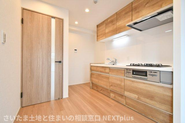 プレジデント98のキッチン|木目調の吊戸棚付きシステムキッチンです。上にも下にもたくさん収納出来ますので、別途で食器棚がなくてもたくさん収納する事ができます！ライトもありますので、お料理中の手元もしっかり照らしてくれます。