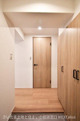 プレジデント98の玄関|玄関は広めに設計されておりますので、お子様と並んで靴を一緒に履く事もできます！木目調のフローリングと白い壁は統一感があり、モダンな玄関です。急な訪問でドアを開けても室内が見えない設計です◎