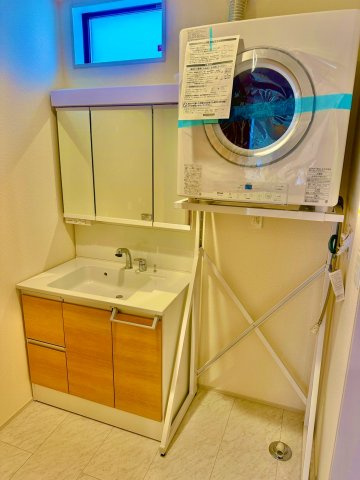 ブルーミングガーデン西原町小那覇・１号棟の独立洗面台|通常よりもワイドなハンドシャワー付き洗面化粧台＆洗濯機置き場にガス乾燥機を設置／ロック機能＆窓付き