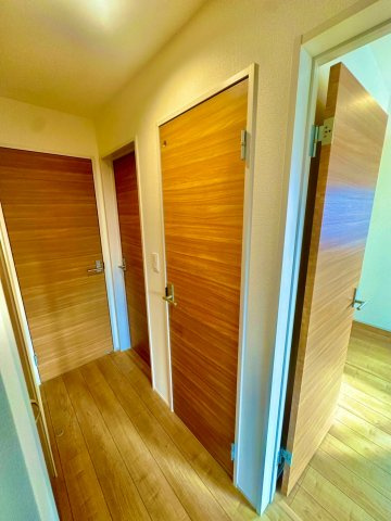 ブルーミングガーデン西原町小那覇・１号棟の内装|２階廊下側から見た、ライフスタイルの変化に対応しやすいフレキシブルプランのお部屋の扉