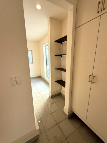 ブルーミングガーデン西原町小那覇・２号棟の玄関|収納力抜群の玄関収納から、カースペースへの同線も良い、サブリビングスペースとしても利用できる「通り土間」