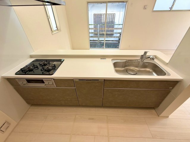 ブルーミングガーデン西原町小那覇・２号棟のキッチン|人造大理石カウンター付きの対面式のシステムキッチン