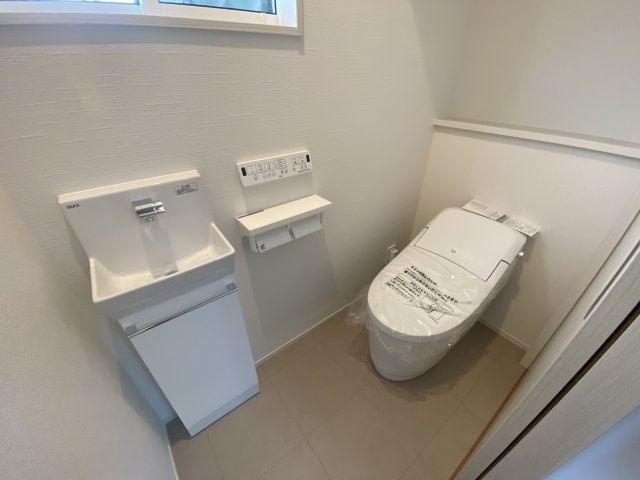 玉里団地1丁目　S-pacio B棟のトイレ|1階の温水洗浄便座トイレです。手洗い場に収納があり、掃除道具を収納することができます。