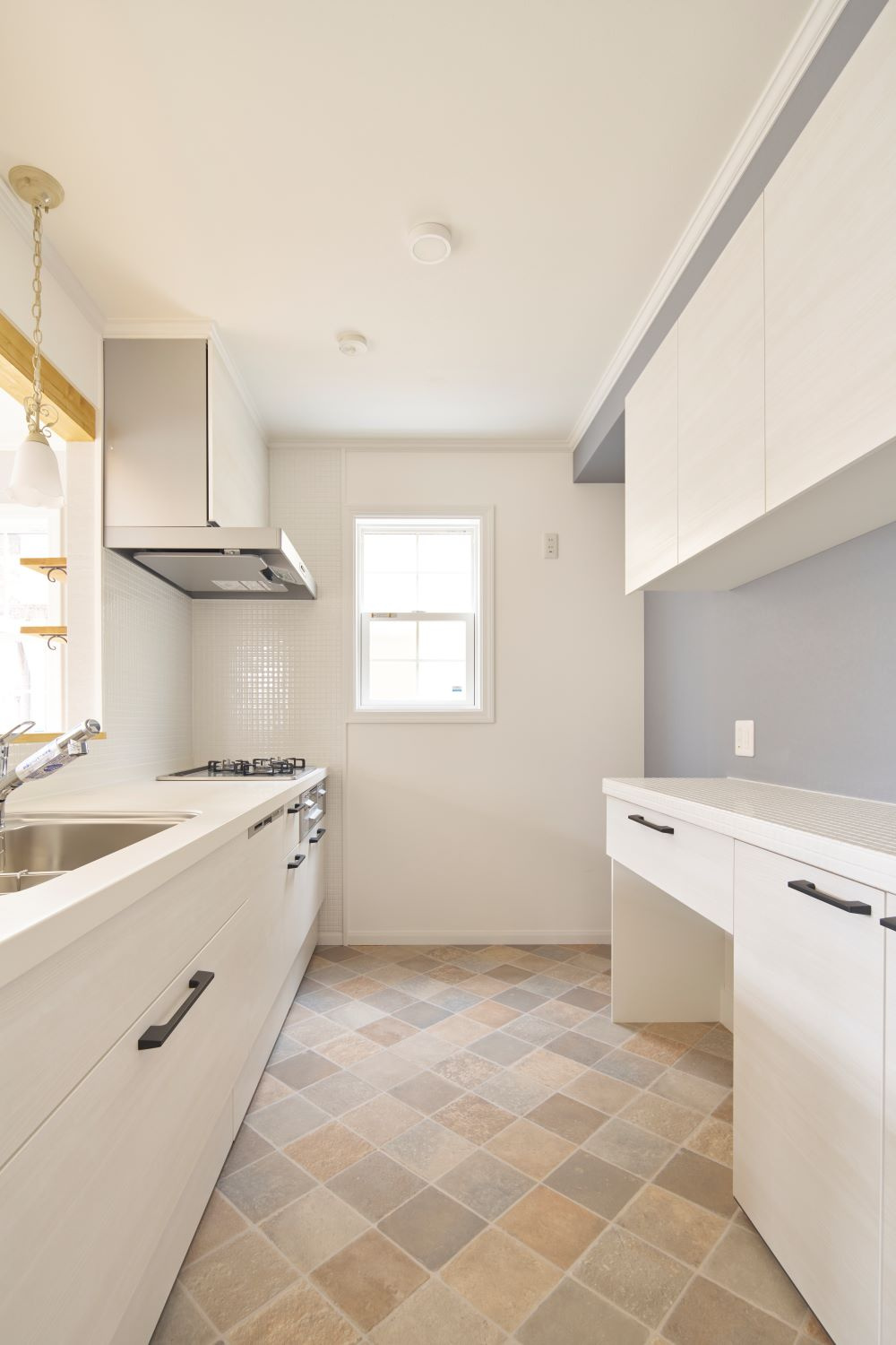 入間郡三芳町大字北永井の新築一戸建のキッチン|ビルトイン食洗器付きのキッチンキャビネット。床や壁のタイル、ペンダントライトがお洒落なキッチンです。