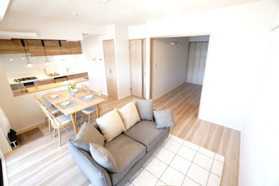 【居間・リビング】 | 【上質リノベ】サーパス宇品 | 【約14.8帖LDK】
ソファに腰かけた瞬間、やさしい木目と整った空気感が
身体にしみ込んでくるよう。
キッチンから奥の洋室まで、光と暮らしがゆるやかにつながり、
思わず、ひとつ深呼吸したくなります。