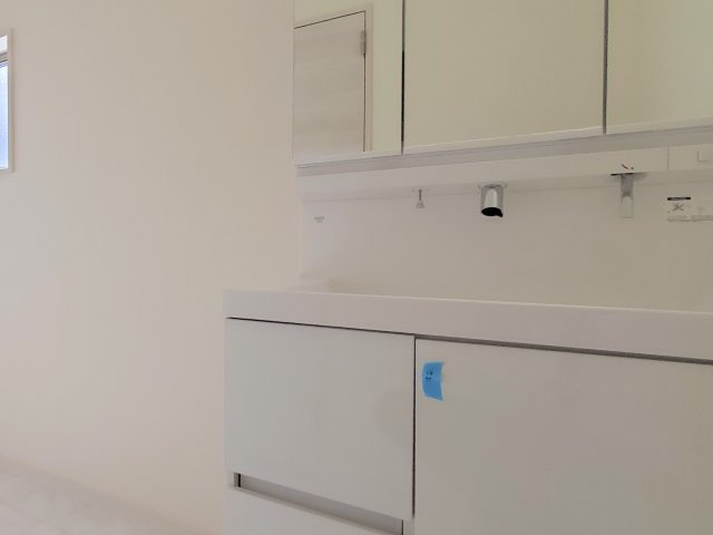 熊本市西区城山半田2丁目第2-6棟（4号棟）の内観：施工例|毎日使うものだから清潔な空間を保ちたい水回り。洗面にはそんな願いを解消させてくれる収納アイデアが満載です。三面鏡の裏側にはキャビネットが現れ小物から背の高い物まで収納できます。