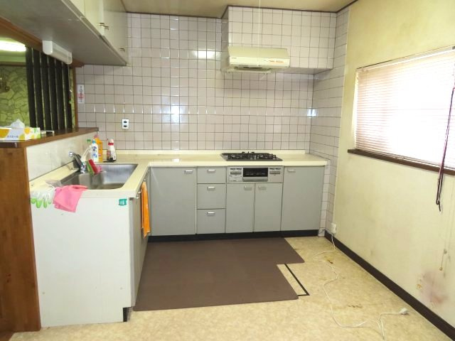 北見市東相内町３１番地１０、３１番地４　中古売家のキッチン|L型キッチンは、シンクとコンロの間を斜めに移動できるため、効率的に調理を進められます。90度のコーナー部分を含め、食材や調理器具を置くスペースにゆとりがあり、複数のお皿を並べて盛り付けやすいです。