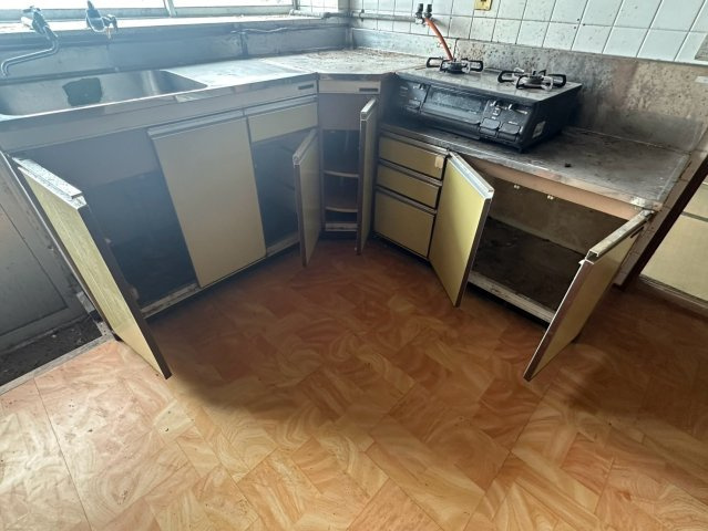 豊岡町大町　中古戸建のキッチン|壁付けタイプのキッチンは、ダイニングスペースを広く使えるのが利点。RC造の建物に合わせた落ち着いた雰囲気で、冷蔵庫や棚の配置も自由自在。自分好みの使いやすい動線にカスタマイズして生活できます。