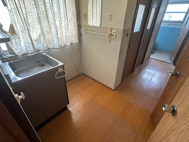 豊岡町大町　中古戸建の洗面所|窓のある明るい洗面室は、湿気が逃げやすく快適な使い心地。広めの脱衣スペースは、着替えや洗濯物の仕分けも楽に行える実用的な設計。生活動線に配慮された配置で、毎日の家事負担を優しく軽減します。