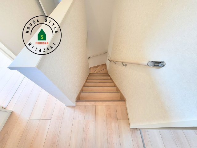 宮崎市淀川3丁目第1-2棟（1号棟）の内装|＜手すり付階段＞手すりがないと階段の昇り降りで危険なことはもちろん、壁に手をつきながら歩くことで壁紙が汚れやすくなります。すべての方に快適に昇り降りしていただくため、手すりを設置しました。