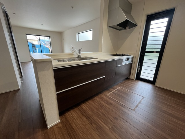 リーブルガーデンＳ第12 富岡七日市　１号棟のキッチン|人気のカウンターキッチン採用です☆ゴミ出しにも便利な勝手口付き！
コンロも３口ご用意しています！調理スペースも広くストレスなくお料理できます。
浄水器つきなので美味しいお水も飲めますよ♪