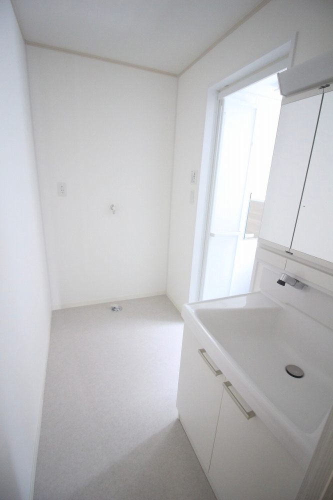 小山市城北4丁目の脱衣所|白を基調とした明るい洗面室。洗濯機置き場もゆとりがあり、動線がしっかり確保されています。