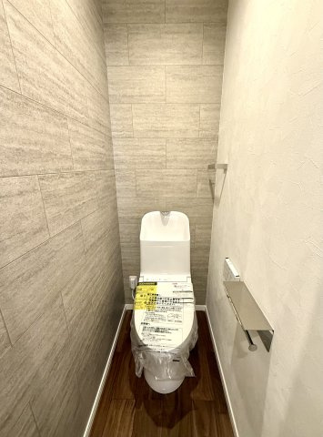 フルリノベ中古戸建　大東市緑が丘1丁目（平成6年築）のトイレ|石目タイル調のアクセントクロスがポイントのトイレです