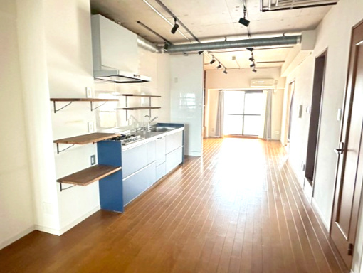 サーパス久保田の居間・リビング|南側に面した広大なLDKは、リノベーションにより柱の少ない一体感のある空間になりました。家具のレイアウトがしやすく、ダイニングとリビングを緩やかに分けられるため、家族が自然と集まる温かな場となります。