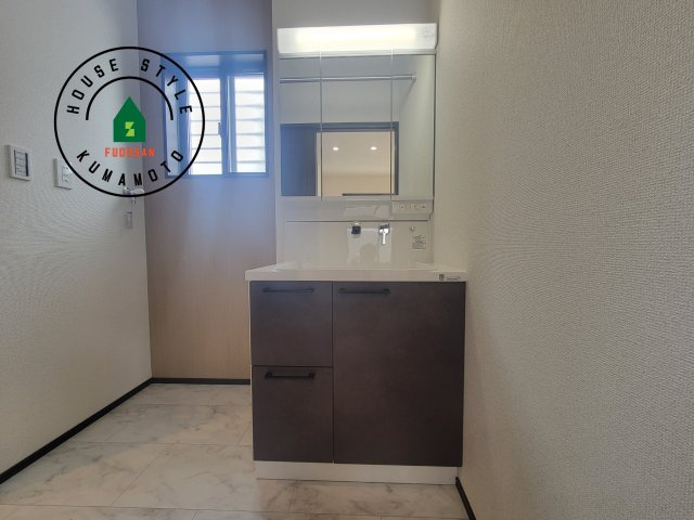 熊本市西区中原町第1-4棟（3号棟）の内観：施工例|毎日使うものだから清潔な空間を保ちたい水回り。洗面にはそんな願いを解消させてくれる収納アイデアが満載です。三面鏡の裏側にはキャビネットが現れ小物から背の高い物まで収納できます。