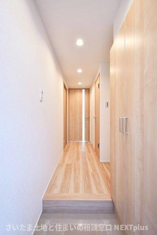 グランドシティ大宮EASTTOWERの玄関|玄関ドアの正面にはリビングの扉が設置されておりますので、急な訪問で玄関を開けた際室内が見えない設計です！木目調のフローリングと白い壁は統一感があり、すっきりとした印象の玄関です。