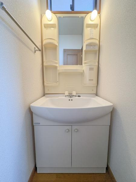 荏隈　中古の独立洗面台|壁付けタイプの洗面台で空間を有効に活用できます。上部には収納スペースがあり整理整頓もしやすい構造です。照明付きで手元が明るくなり日常の利用に便利です。シンプルなデザインで清潔感があります。