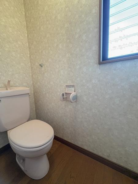 荏隈　中古のトイレ|窓付きで自然光が入るため明るい印象のトイレです。壁紙は落ち着いたデザインで清潔感があります。床材はお手入れしやすく日常の使用に便利です。ペーパーホルダーも使いやすい位置に設置されています。
