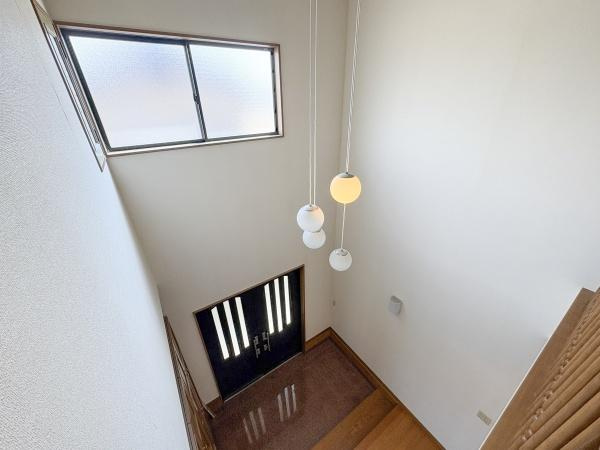 荏隈　中古の内装|玄関吹き抜けの開放感が印象的です。上下階に明かりを取り入れる窓があり明るさが感じられます。モダンな照明が空間を引き立てています。落ち着いた色合いの玄関ドアがアクセントです。