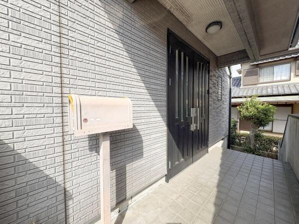 荏隈　中古の玄関|玄関には屋根があり天候に左右されにくい設計です。タイル張りのアプローチが清潔感を感じさせます。ポストも設置されており便利な仕様となっています。広めのスペースがゆとりを感じさせる玄関エリアです。