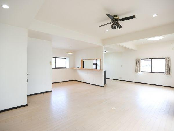 葛木　中古の居間・リビング|広々とした空間が魅力的なリビングです。天井のファンがアクセントとなっており明るい雰囲気が広がります。窓が多く採光も良好です。キッチンとのつながりもあり使い勝手が良いです。