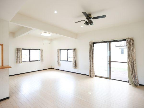 葛木　中古の居間・リビング|リビングは大きな窓から光が入り明るさが広がります。天井にはシーリングファン付きで換気も快適です。床はナチュラルカラーで落ち着いた印象です。ゆとりある空間が広がっています。
