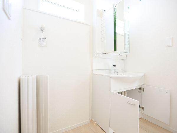 挾間町下市第1-4号棟の独立洗面台|明るい空間に設置された洗面台で清潔感が感じられます。収納スペースも確保されており使い勝手に配慮されています。鏡が付いたシンプルなデザインが特徴的です。足元の収納も有効活用できます。
