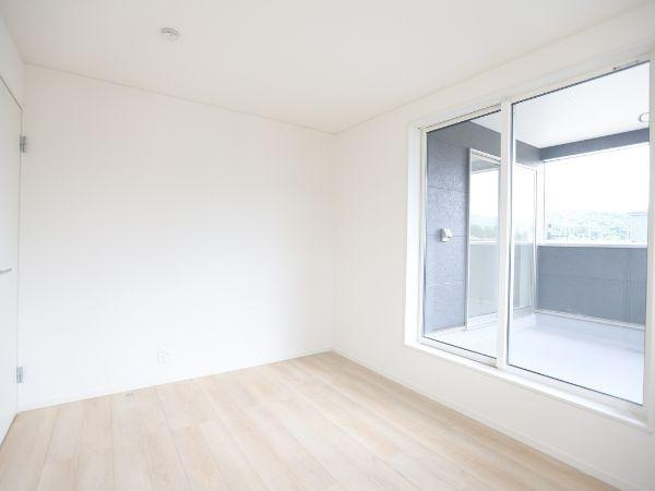 挾間町下市第1-4号棟の洋室|明るい色合いのフローリングが特徴的な洋室です。大きな窓からたっぷりと光が入るため室内がより一層広く感じられます。ホワイトを基調とした内装がシンプルでどんなインテリアにも合わせやすい空間です。