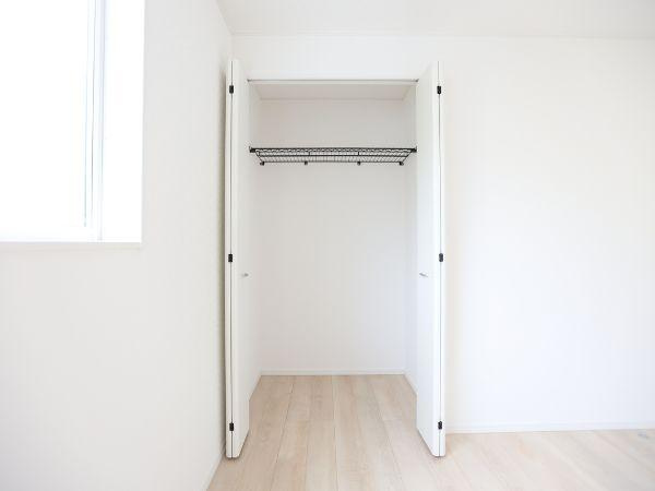挾間町下市第1-4号棟の収納|白を基調とした内装に調和する収納スペースです。両開き扉で荷物の出し入れがしやすい設計です。クローゼット内はシンプルなハンガーパイプ付きで衣類などをスッキリまとめられます。