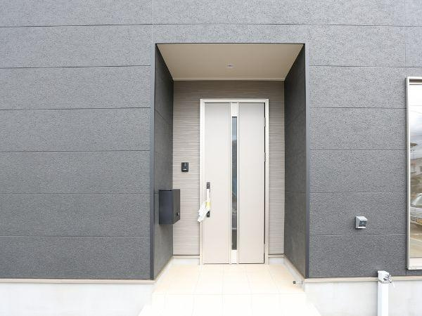 挾間町下市第1-4号棟の玄関|シンプルですっきりとしたデザインの玄関です。スタイリッシュな外壁と調和した印象があります。玄関ドアはモダンな雰囲気を感じる色合いです。明るいタイルのアプローチが印象的です。