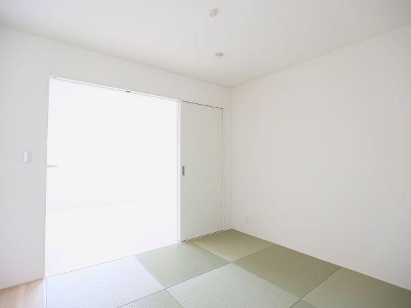 挾間町下市第1-4号棟の和室|シンプルな内装で落ち着いた雰囲気の和室です。白を基調とした壁が空間をすっきりと見せています。引き戸が設けられ隣室とつなげて使うことも可能です。光が差し込む明るい空間です。