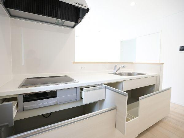 挾間町下市第1-3号棟のキッチン|シンプルなデザインのキッチンです。収納スペースが豊富で整理整頓しやすい仕様となっています。IHコンロとシンクが効率的に配置されています。開放感のある空間が印象的です。清潔感を感じる色合いです。