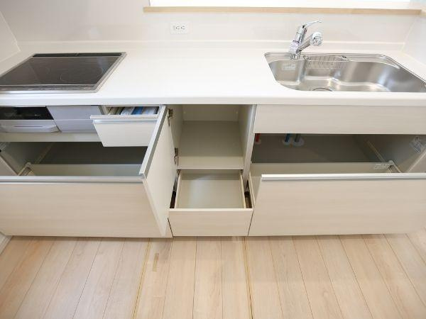 挾間町下市第1-3号棟のキッチン|シンプルなデザインが魅力のキッチンです。収納スペースが複数あり整理がしやすくなっています。IHコンロと広々としたシンクを備えています。作業がしやすいレイアウトです。