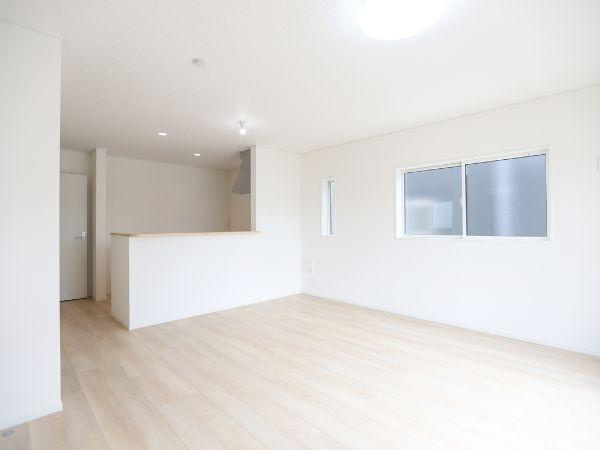 挾間町下市第1-3号棟の居間・リビング|大きな窓から自然光がたっぷり入るリビングです。明るいフローリングが空間を開放的に見せます。白を基調とした内装がさまざまなインテリアに合わせやすいです。キッチンとの繋がりも魅力です。