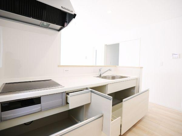 挾間町下市第1-2号棟のキッチン|清潔感のあるキッチンで収納スペースがしっかり確保されています。IHコンロと換気扇が設置されすっきりとしたデザインです。引き出しや扉の開閉もスムーズで使いやすい印象を受けます。