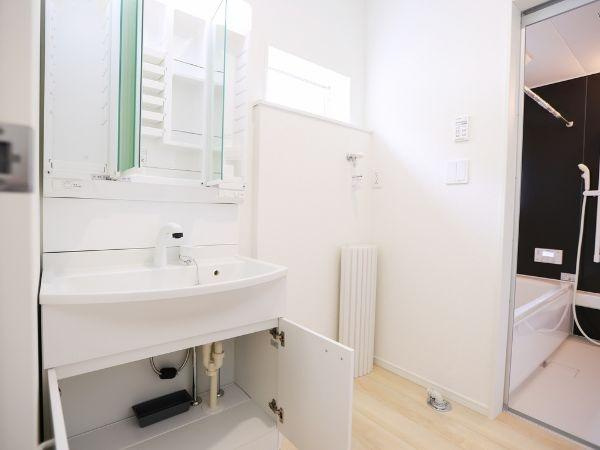 挾間町下市第1-2号棟の独立洗面台|洗面台下の収納スペースが広く日用品の整理がしやすい仕様です。シンプルなデザインの洗面化粧台が設置されています。明るい室内で使い勝手の良い間取りです。浴室への動線もスムーズです。