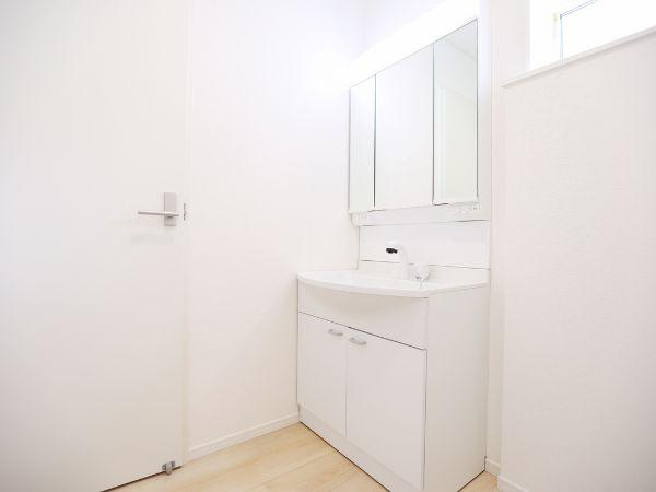 挾間町下市第1-2号棟の独立洗面台|清潔感のある白を基調とした洗面台が設置されています。すっきりとしたデザインで使いやすさが感じられます。三面鏡が採用されており収納力も期待できます。換気に便利な窓も設置されています。